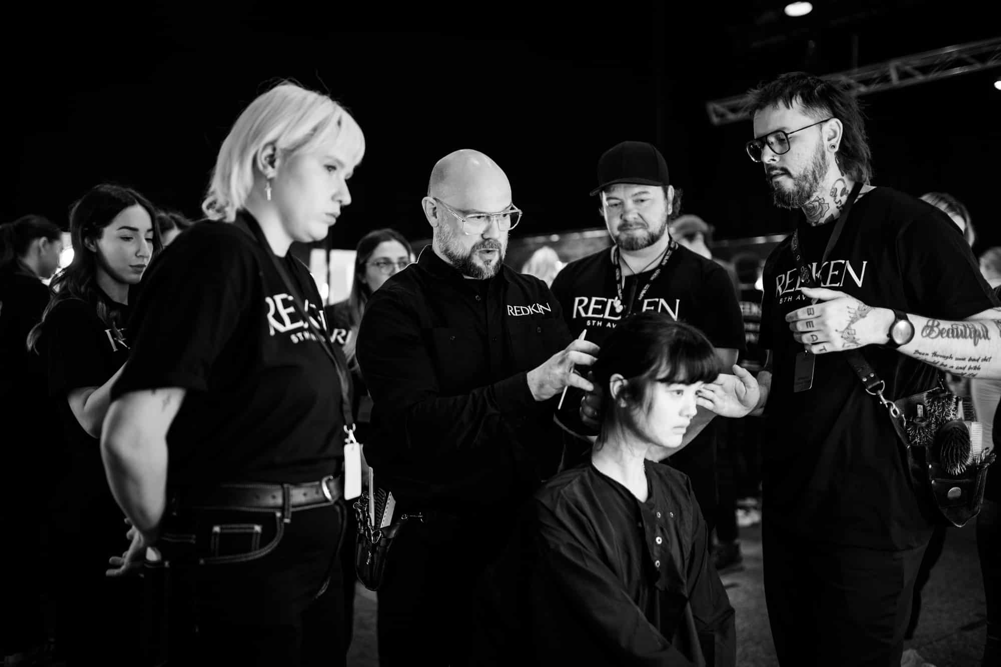Afterpay Australian Fashion Week 2023 - Redken Hair Director, Justin Pace doing a model's hair surrounded by four Redken Backstage Styling Crew Members