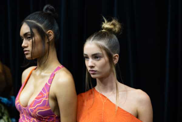 Afterpay Australian Fashion Week 2023 - hair by Redken Hair Director, Justin Pace and the Redken Backstage Styling Crew - two models ready to walk the runway with loose hair strands, slicked back hair and a top knot