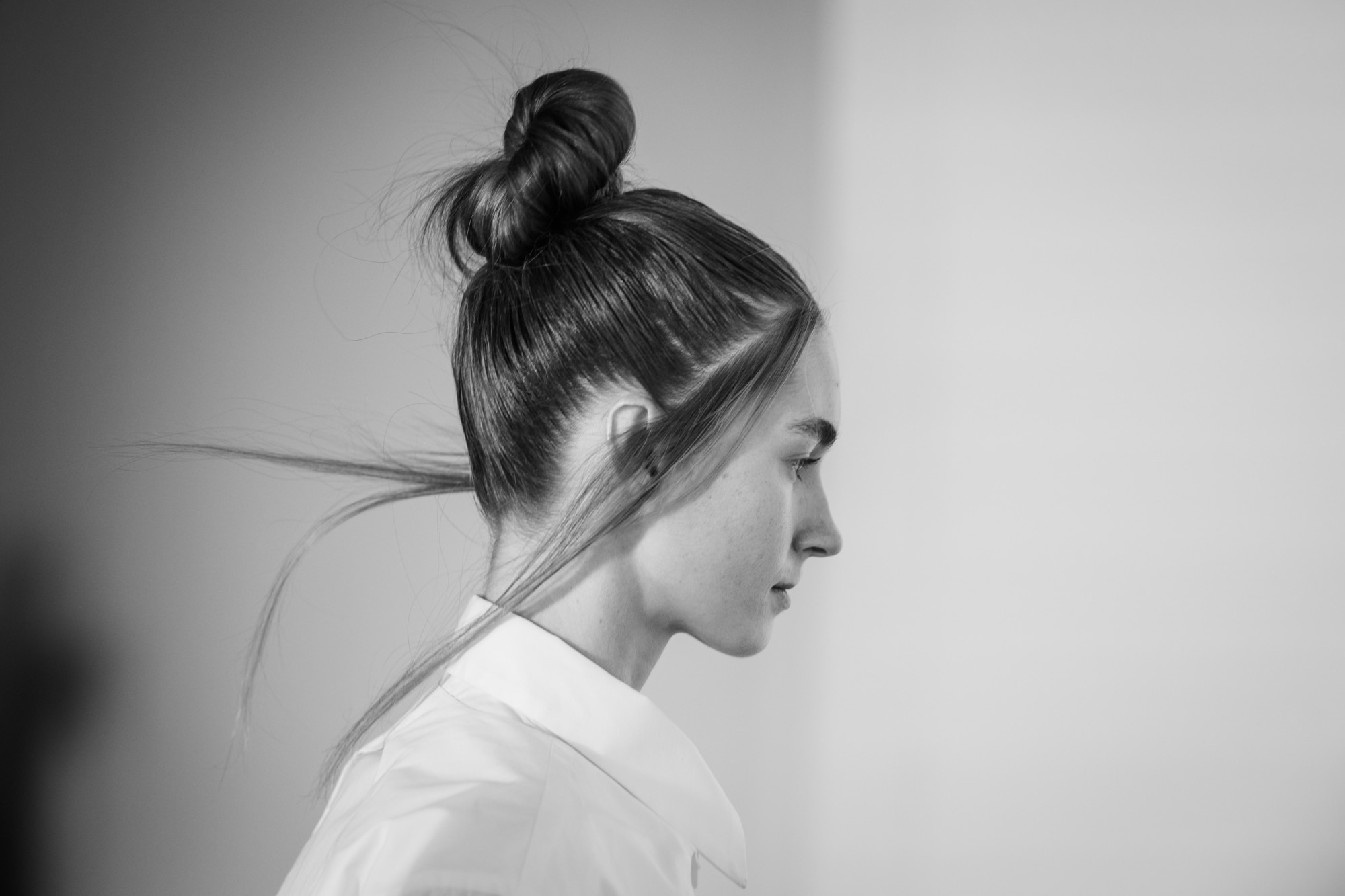 Afterpay Australian Fashion Week 2023 - hair by Redken Hair Director, Justin Pace and the Redken Backstage Styling Crew - model walking down the runway with loose hair strands, slicked back hair and a top knot